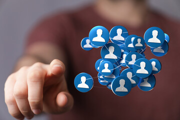 Hand pointing towards a network of connected people icons. Represents community, social, connections, teamwork, and digital networking in the wo