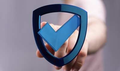 A person's hand reaches out towards a digital shield with a check mark, representing concepts like...