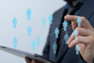 Concept of teamwork, connection, and social networking with digital icons. Businessman using a tablet to connec