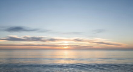 Obraz premium Serene ocean sunset with soft clouds and gentle waves