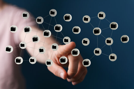 Abstract depiction of digital connection and data flow. Hand interacting with a network of folders representing