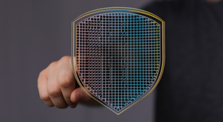 Hand holding a digitally rendered shield, symbolizing cyber security, data protection, and online safety. Modern concept of defense a