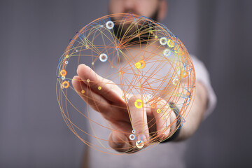 Close-up of a man's hand touching a digital sphere representing global connection, innovation and technology.