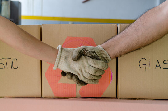 Two volunteers shaking hands after a work day.Recycle concept.Earth Day concept. - Powered by Adobe