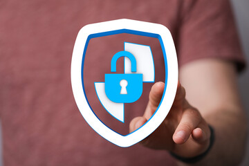 A person's hand pointing at a blue padlock and shield icon, symbolizing cybersecurity, protection, and privacy in a digital world.