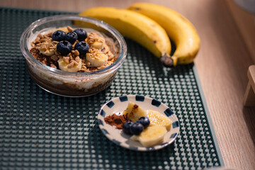 Overnight oats in glasses topped with banana slices and blueberries.