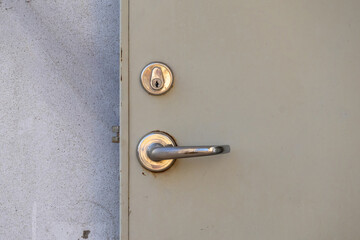 Close-up of a modern, installed steel security door featuring a stylish Door Lever Set and a standard mechanical lock cylinder (key cylinder, lock core) for residential or commercial security.
