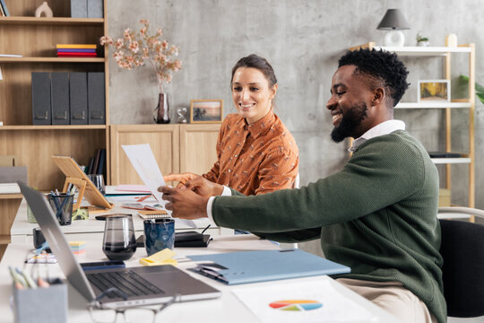 Diverse colleagues collaborating and discussing documents in office