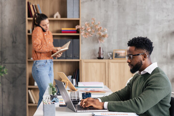 Professionals collaborating in a modern office working on laptops