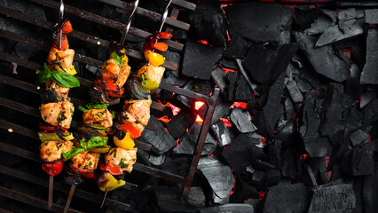 Assortment of Grilled kebab skewers on a background of hot coals. Barbecue, cooking meat on fire. © Yaruniv-Studio