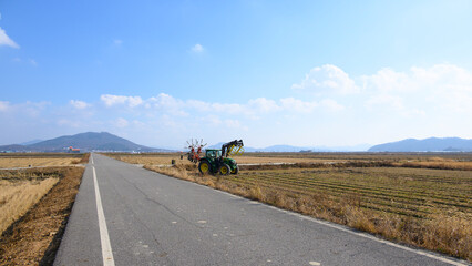 A view of Ganghwado's rice fields and a circular baler. Autumn rice fields after harvest. A view of Gyodongdo Island in Ganghwado. Korean traditional rice farming.