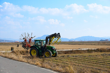 A view of Ganghwado's rice fields and a circular baler. Autumn rice fields after harvest. A view of Gyodongdo Island in Ganghwado. Korean traditional rice farming.