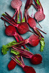 Background of fresh young beets with stems. Sliced beets on a stone background. Top view.