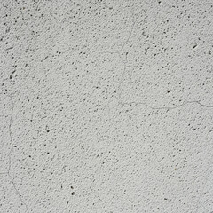 white textured concrete wall with small pores and subtle surface cracks creating a rough minimalist background pattern