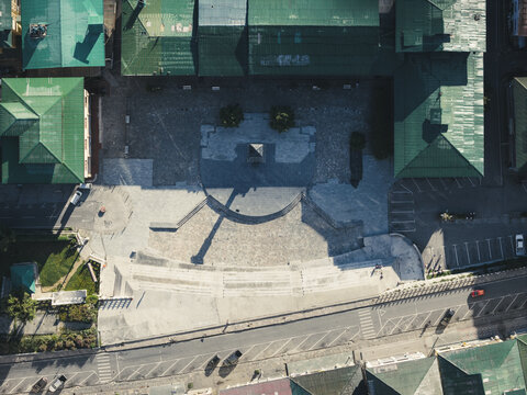 Aerial view of the clock tower square and grey stone textures meet the green rooftops in the heart of the city, a contrast of nature and urban design, Thimphu, Bhutan.
