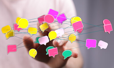 Hand reaching towards a network of colorful speech bubbles, symbolizing communication and connection.