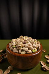 Bol de pistache et rideau noir, intérieur, vertical