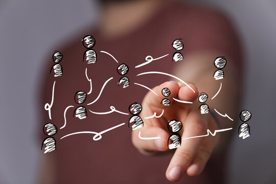 Hand interacts with a virtual interface displaying interconnected human figures, symbolizing global business networking, social connections, and