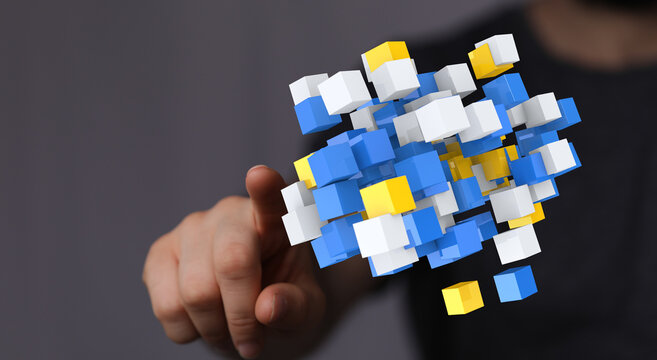 Hand pointing at floating cubes representing digital network connection, data, or technology. Abstract modern c