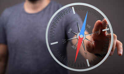 Business professional pointing at compass, symbolizing direction, guidance, and the concept of navigation and strategy in a modern business cont