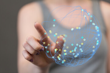 Close-up of a hand interacting with a glowing digital network sphere, representing global connection and technology.