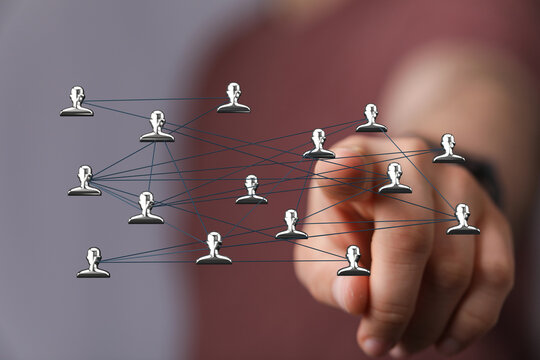 Hand pointing at a network of connected people icons. Represents concepts like communication, social media, teamwork, and business connections. - Powered by Adobe