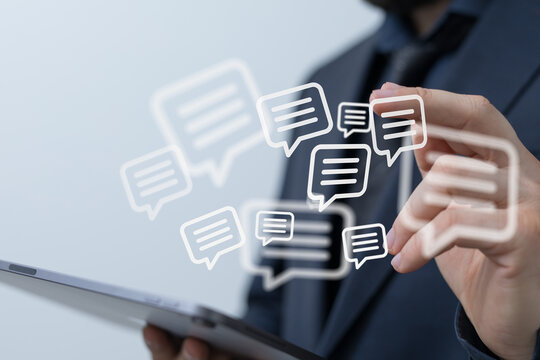 Close-up of a businessman using a tablet with message bubbles overlay, representing communication and social media interaction.
