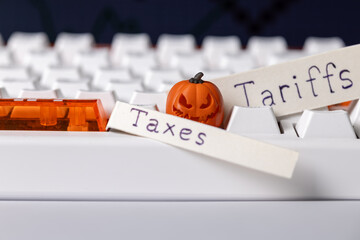 taxes and tariffs loom over the economy, symbolized by a miniature jack-o'-lantern on a clean computer keyboard, representing economic fears and halloween