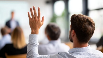 Man raising hand asking question during seminar, participating in conference, training, or educational event