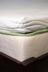 Topper mattress with a core of pressure-relieving gel foam. Adapts to body and leads away excess heat. White soft mattress. Vertical photo.