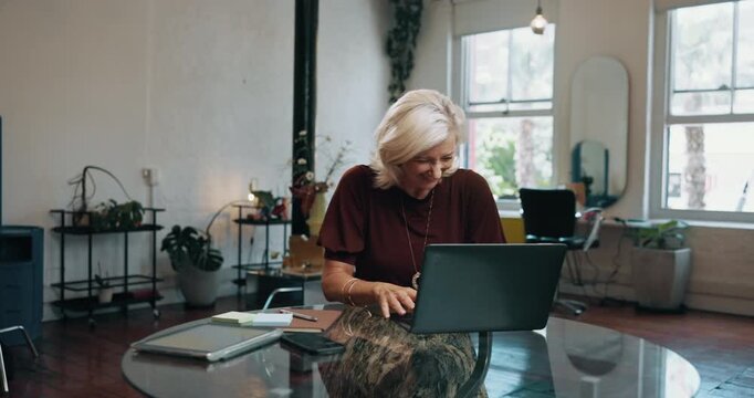 Mature woman, winning and celebration with laptop for good news or online booking in beauty salon. Female person, entrepreneur or hairdresser with smile on computer for business success in parlor
