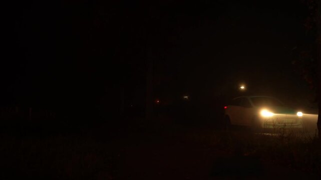 Road traffic in fog at night. Diffuse car headlights at night.