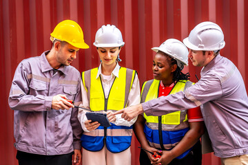 Happy diverse group of engineers workers checking inventory with tablet device in the container yard background. This is a freight transportation and distribution warehouse.