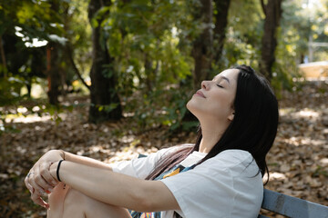 Young woman enjoying tranquility in nature, soaking up sunlight and finding peace outdoors