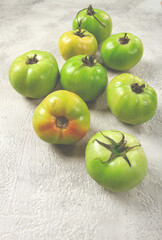 green tomatoes scattered on the table, unripe tomatoes, raw , selective focus, no people,