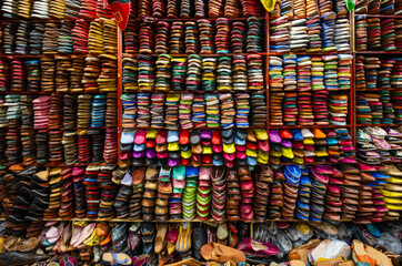 Colorful display of traditional footwear neatly arranged on shelves in a market stall. Fez, Fez-Meknes, Northern Inland Morocco