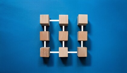 wooden cube blocks arranged in a flowchart against a blue background symbolizing business process automation with shadows casting toward the bottom left