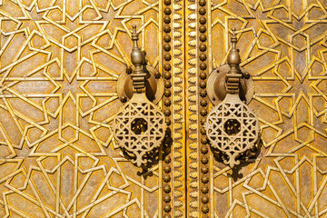 Ornate wooden door with intricate geometric patterns and traditional brass knockers. Fez, Fez-Meknes, Northern Inland Morocco