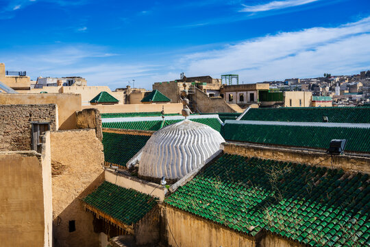 Rooftop view of historic architecture with green tiled domes under a vibrant blue sky. Fez, Fez-Meknes, Northern Inland Morocco