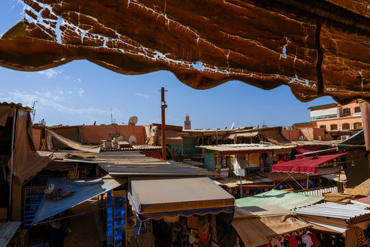 Rooftop view of a vibrant market with assorted canopies under a bright, sunny sky. Marrakesh, Morocco
