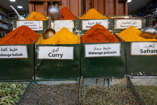 Various colorful spices in labeled containers at a spice market. Marrakesh, Morocco - Powered by Adobe