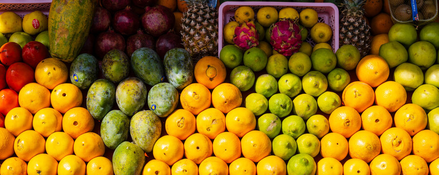 Vibrant display of assorted fruits including mangoes, oranges, apples, and dragon fruits. Marrakesh, Morocco