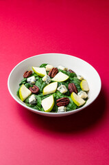Salad with spinach, blue cheese, pear, and nuts. Healthy eating. Vegetarian food.