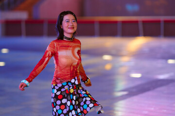 Woman ice skating indoors with colorful attire and a joyful expression. Shanghai, China