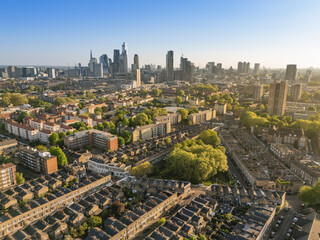 Aerial view of London skyline with modern skyscrapers and residential buildings under clear sky. London, UK