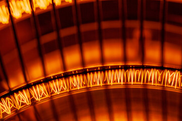 Close-up of glowing orange heating element with wire cage design.