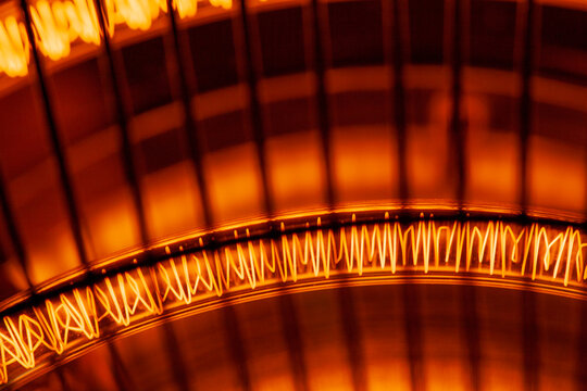 Close-up of glowing orange heating element with wire cage design.