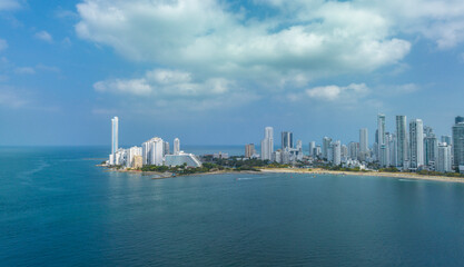 Coastal city skyline with high-rise buildings under a partly cloudy blue sky. Cartagena, Colombia