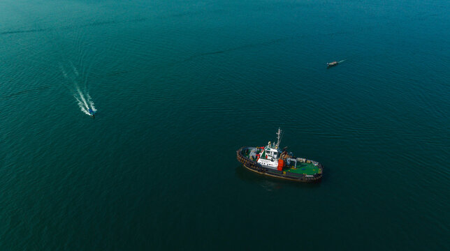 Tugboat and small vessels navigating through calm blue ocean waters. Cartagena, Colombia