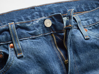 Close-up of blue denim jeans with a zipper partially undone and button undone.